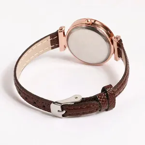 Detail view of the rose gold case and brown faux leather strap with crocodile pattern