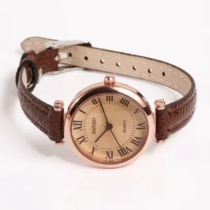 Detail view of the rose gold dial with Roman numerals and brown leather strap