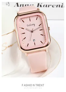Gros plan d'une montre carrée rose avec boîtier en métal or rose et guichet de date
