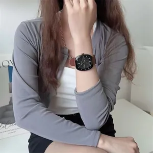 Wrist view of a stylish square black dial watch with a premium brown leather strap