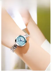 Détail du bracelet en acier argenté avec cadran en nacre bleu clair porté au poignet