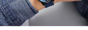 Close-up of a blue silicone strap watch on a wrist with navy knit sleeve background