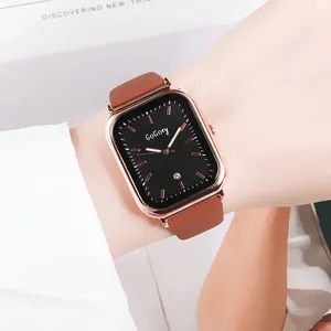 Montre carrée élégante en or rose avec cadran noir et bracelet en cuir marron au poignet