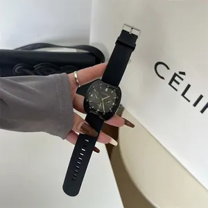 Close-up of a square black quartz sports watch with a silicone strap held by a hand