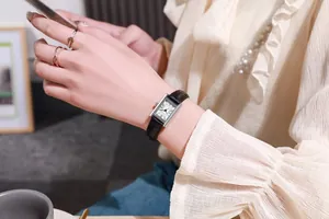 Close-up of retro rectangular ladies watch with black leather strap on a model's wrist