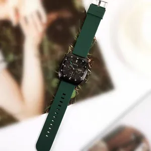 Close-up of square green silicone watch with black dial and metallic buckle detail