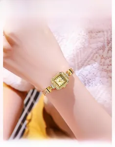 Détail d'une montre carrée vintage de luxe pour femme avec chaîne en or et cristaux