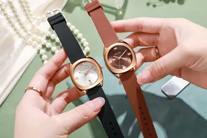 Detail van roségoud quartz horloge met siliconen band en datumvenster op de wijzerplaat