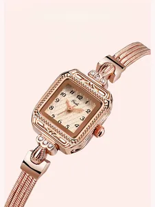 Détails d'une montre carrée en or rose avec motifs floraux gravés et cristaux brillants