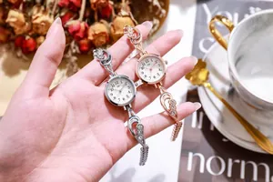 Primo piano di eleganti orologi a maglie cave in argento e oro rosa con strass luccicanti