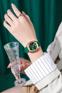 Detailopname van elegant dameshorloge met groene wijzerplaat en bijpassende gouden ring