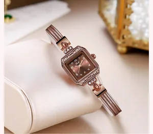 Détail de montre carrée en or rose avec cadran brun soleil et accents de cristal