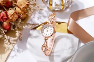 Dettaglio dell'orologio a bracciale oro rosa con strass su vassoio di marmo
