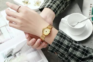 Détail de la montre à quartz dorée avec bracelet extensible et cadran à chiffres