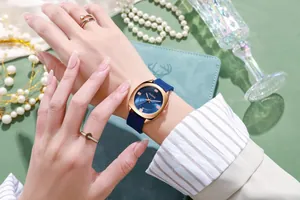 Detailopname van een blauw quartzhorloge met roségouden kast en stijlvolle ringen