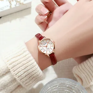 Elegant rose gold quartz watch with red leather strap worn in a lifestyle setting
