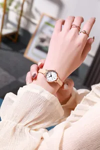 Detailed view of women's quartz watch with rose gold case and beige leather strap