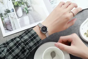 Détail d'une montre à quartz argentée avec cadran noir et bracelet en métal élastique