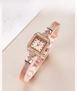 Détail d'une montre vintage carrée or rose avec cadran à motifs et bracelet en maille fine