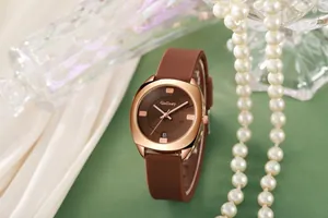 Macro-opname van roségouden horloge met bruine siliconen band en datumvenster
