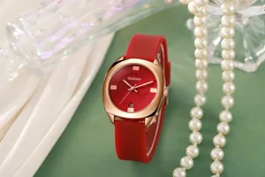 Detail van elegant rood siliconen horloge met roségouden kast op parelachtige basis