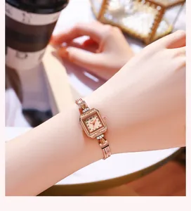 Détail d'une montre à quartz vintage carrée en or rose avec des cristaux décoratifs au poignet