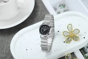 Détail du petit cadran noir avec chiffres arabes et bracelet extensible en acier argenté