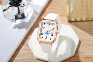 Detailweergave van vierkant roségoud quartzhorloge met witte siliconen band op marmer