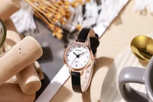 Detail view of the rose gold quartz watch with a white dial and black leather strap