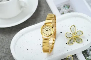 Vue détaillée d'une montre à quartz dorée sur un plateau décoratif avec guichet de date