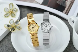 Gros plan de montres à quartz élégantes en or et argent avec cadrans ronds sur plateau