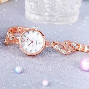 Detail of rose gold quartz watch with mother-of-pearl dial and crystal heart bracelet