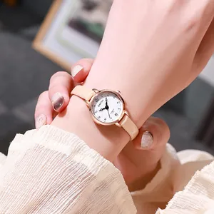 Elegant ladies quartz watch with rose gold case and beige leather strap on wrist