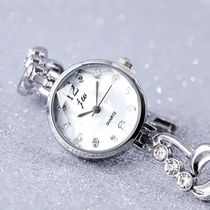 Detail of luxury women's quartz watch with silver crystal chain and mother of pearl dial