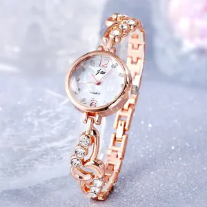 Detail of rose gold ladies watch with mother of pearl dial and rhinestone heart bracelet