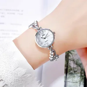 Close-up of silver steel watch with crystal-encrusted bezel on a woman's wrist