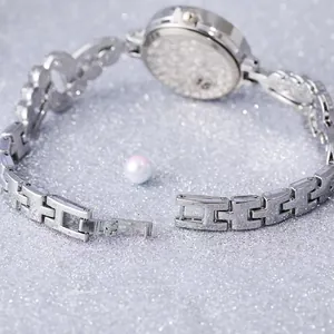 Close-up of the silver metal H-link watch band and engraved stainless steel case back