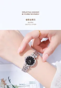 Close-up of a silver metal link watch with a black dial and sparkling crystal indices