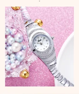 Detalle del reloj pulsera plateado Gedi con pedrería sobre fondo de perlas rosas