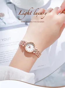 Close-up of rose gold watch with crystal indices and metal link strap on wrist