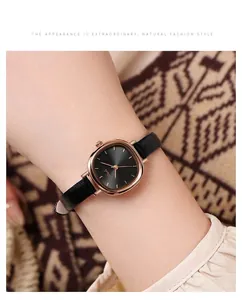 Close-up of minimalist rose gold quartz watch with black sunray dial and slim leather strap
