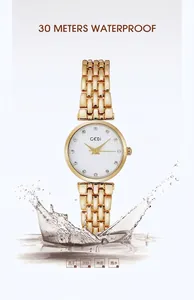 Detail of GEDI gold metal watch showing 30M waterproof rating and sparkling water splash
