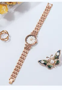 Detailopname van GEDI roségouden horloge met strass, vlinderbroche en bijpassende ring