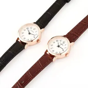 Detail of elegant quartz watches with rose gold cases and leather straps showing date function