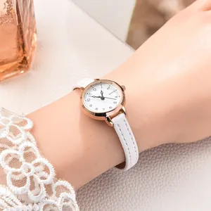 Close-up of elegant small dial quartz watch with white leather strap and rose gold case