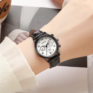 Elegant women's quartz watch with white triple-dial face and black leather strap worn