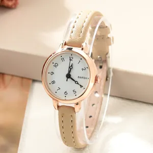 Detail of rose gold quartz watch with white dial and beige leather strap on a stand