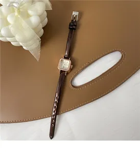 Dettaglio dell'orologio al quarzo quadrato vintage con cassa oro rosa e cinturino marrone