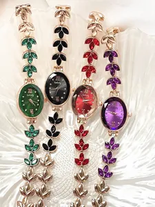 Close-up of four leaf-shaped jewelry watches with colorful gems and rose gold bands