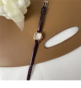Vista dettagliata di un orologio quadrato in oro rosa con cinturino in pelle viola lucida